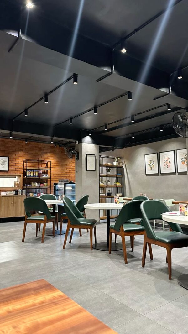 Modern Industrial-Style Café Interior with Green Leather Chairs